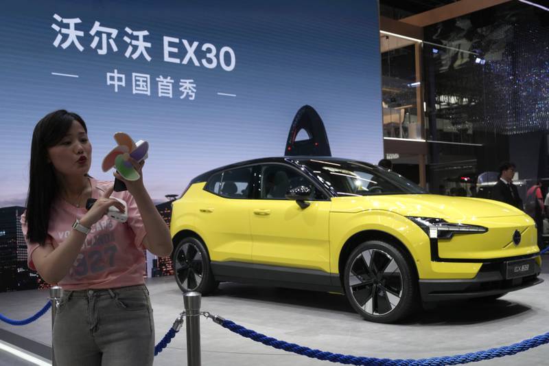 A live streamer works near the Volvo EX30 fully electric small SUV unveiled during Auto China 2024 in Beijing.