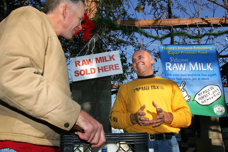 Veterinarian Patrick Smith (left) discusses raw milk with dairyman and producer Mark McAfee at the Farmer’s Market in Fresno in central California.