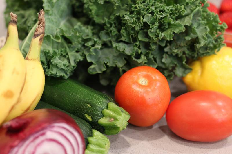 Groceries lay on a kitchen counter before being sorted for storage in the pantry and refrigerator.