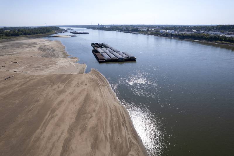 Barges float in the Mississippi River as a portion of the riverbed is exposed last September in St. Louis.