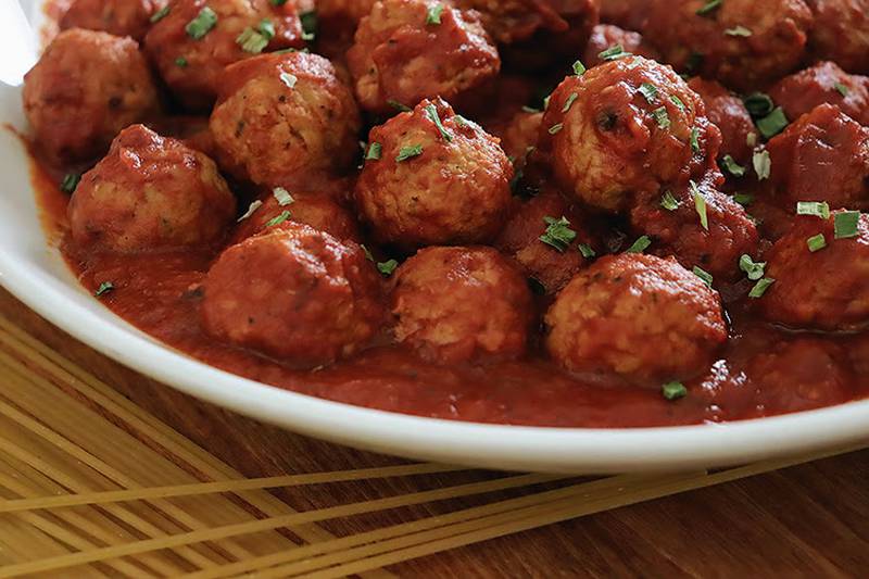 Homemade meatballs in marinara ready to tantalize taste buds and warm hearts.