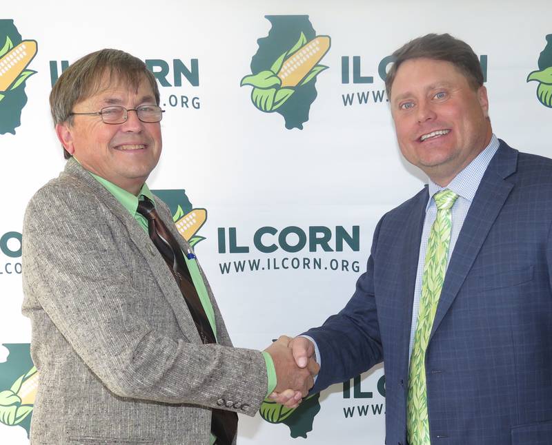 Dave Rylander (left), Victoria, Illinois Corn Growers Association's immediate past president, congratulates newly seated president Garrett Hawkins, Waterloo, after ICGA's annual re-organizational meeting in Bloomington.