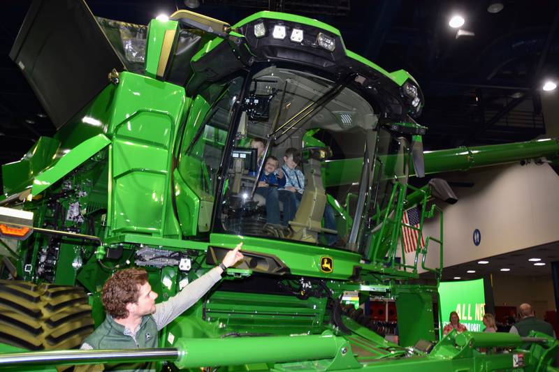 Bergen Nelson, John Deere go-to-market manager for harvesters, points out the features of the new S7 Series of combines introduced at the Commodity Classic convention in Houston.