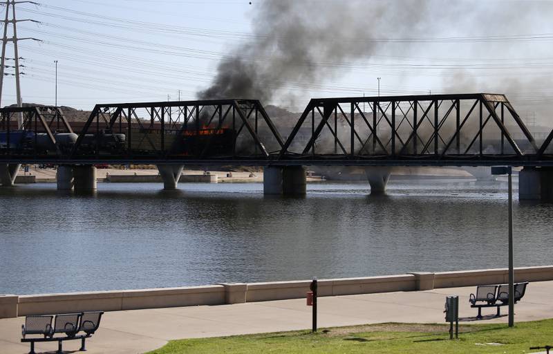 A derailed freight train burns on a bridge spanning Tempe Town Lake in July 2020 in Tempe, Arizona.