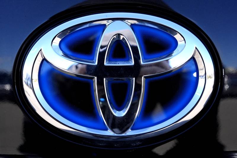 The blue Toyota logo is seen on a hybrid model at a new and used vehicles dealership in Palatine, Illinois.
