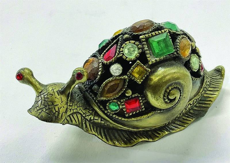 In real life, snails are unwelcome pests. But this one brings the shine of brass and colorful glass instead of leaving slime trails.