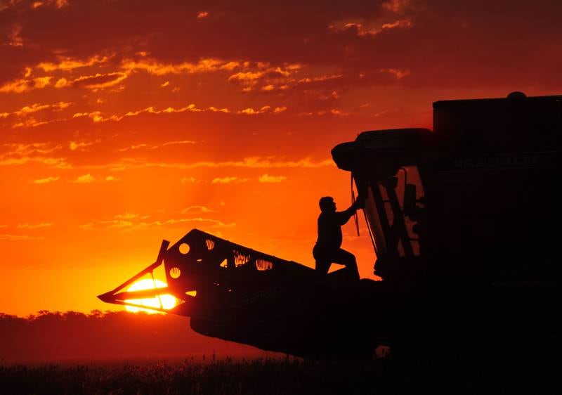 A farm worker sets up his equipment to harvest soybean seeds for export at a farm near Ines Indart, Buenos Aires province, Argentina.