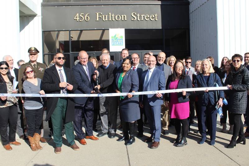 The opening of the new Peoria office for Corn Belt Ports is celebrated with a ribbon cutting that included elected officials, Illinois waterway stakeholders and members of the community. Along with Rita Ali, mayor of Peoria, and John Kahl, mayor of East Peoria, the ribbon was cut by Bob Sinkler (holding scissors on left) , executive coordinating director of Corn Belt Ports, and Dan Silverthorn (holding scissors on right), chair of the Heart of Illinois Regional Port District Board.