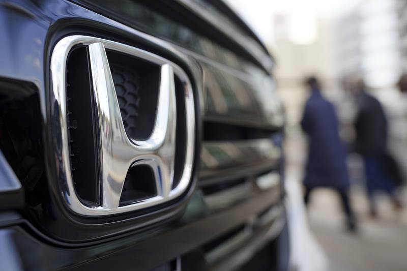 People walk near the logo of Honda Motor Company at a showroom  in Tokyo.
