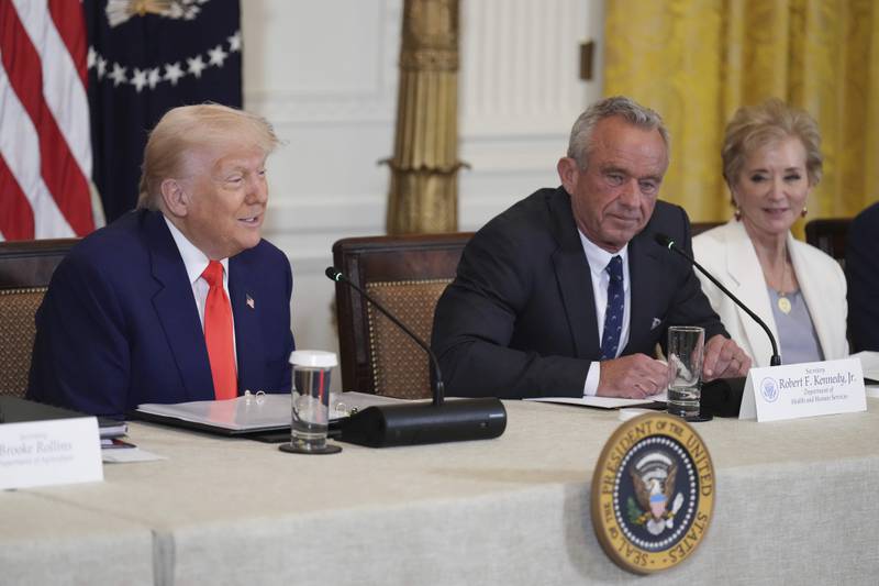 President Donald Trump (left) speaks as Education Secretary Linda McMahon (right) and Health and Human Services Secretary Robert F. Kennedy Jr. listen at a Make America Healthy Again Commission Event in the East Room of the White House in Washington.