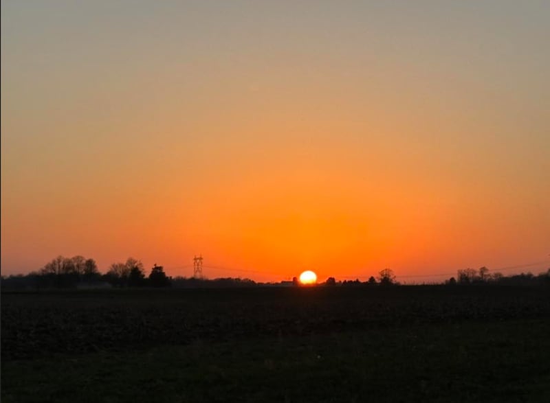 The sun sets over a field in northern Indiana.