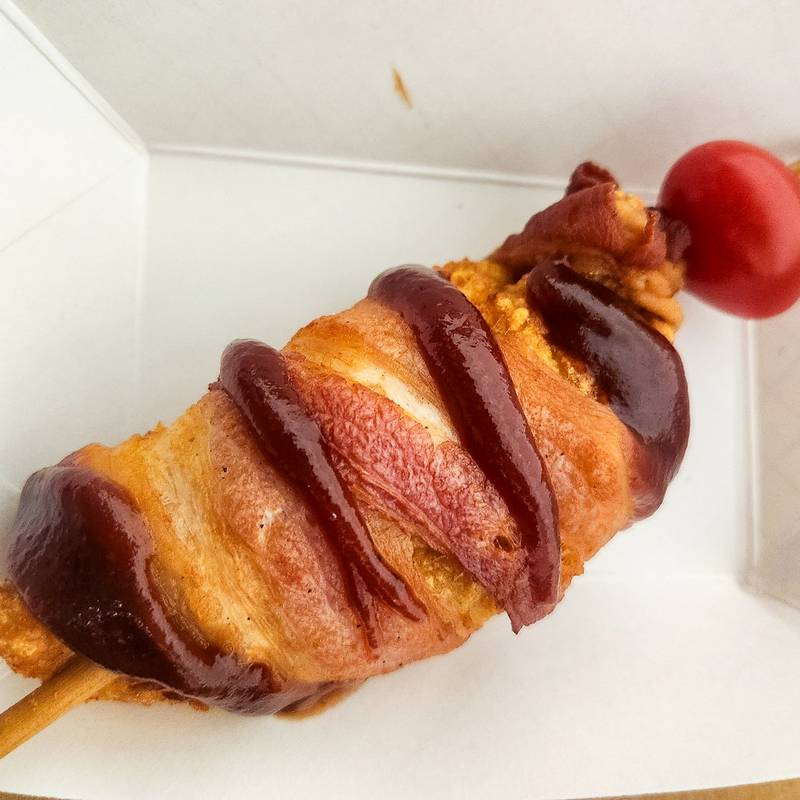 Bacon Wrapped BBQ Chicken on a Stick by R.E. Smith Food and Drink. Fresh chicken tender, hand dipped in batter. Wrapped with delicious bacon and brush with Sweet Baby Ray's barbecue sauce topped with a cherry tomato. Served on a stick.