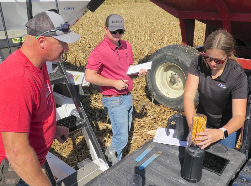 Carlee Lee, Golden Harvest developmental sales representative, and Josh Morgan, LG Seeds district sales manager, document data from their respective corn samples harvested from Aaron Rients’ (left) test plots. Rients planted the corn test plots on April 22.