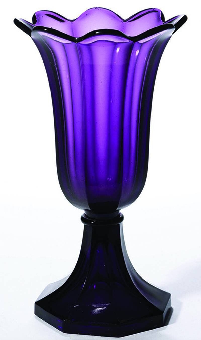 Amethyst glass was made to resemble the purple stone. The simple design of this pressed glass vase puts the focus on its color.