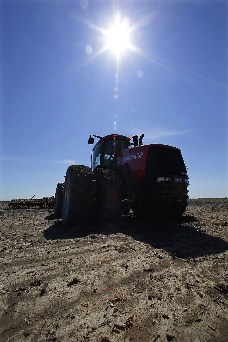 A tractor with cultivator sits idle after being delayed by wet weather.