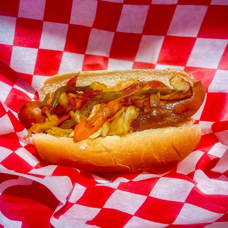 Sweet Heat Sausage Sandwich by R&W Concessions. Jalapeño sausage smothered in sweet BBQ sauce topped with sautéed onions, sweet peppers and cabbage served on a bun.