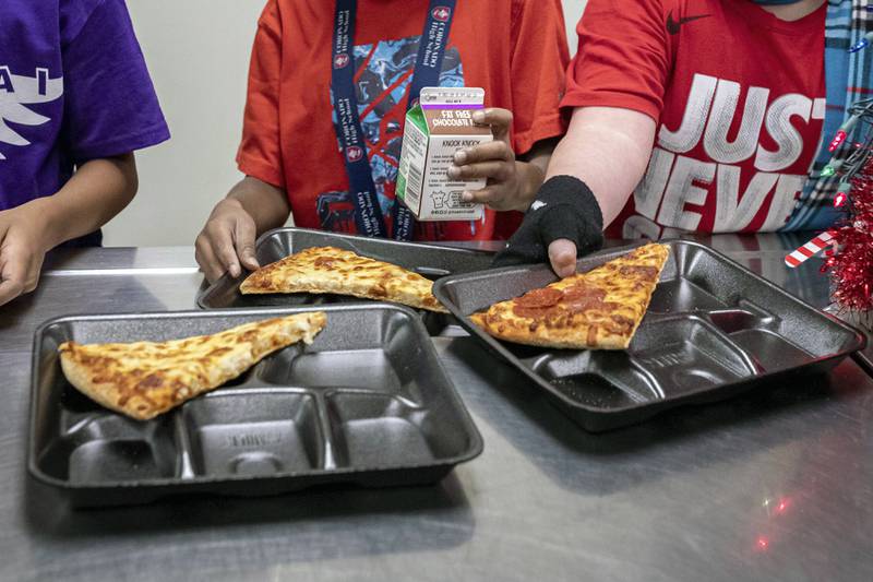 Students select their meals during lunch break in the cafeteria at an elementary school.
