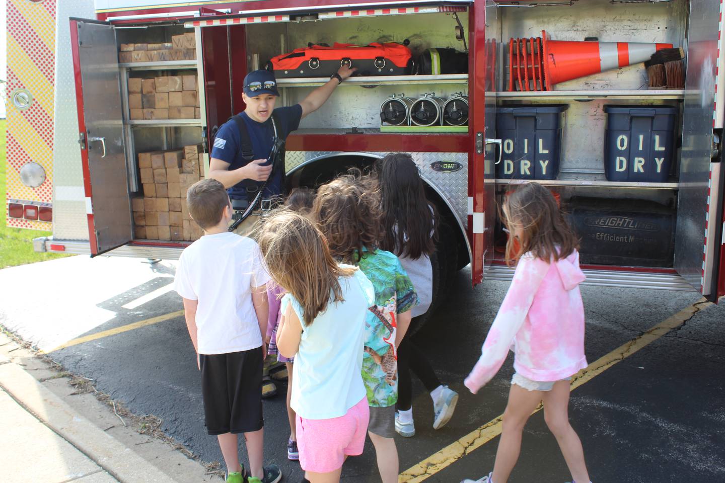 Bryan Gorsky describes equipment on the fire engine to kids during the FFA Ag Safety Day at the Hinckley-Big Rock High School. About 600 students learned about ag safety during the day that also included a petting zoo.