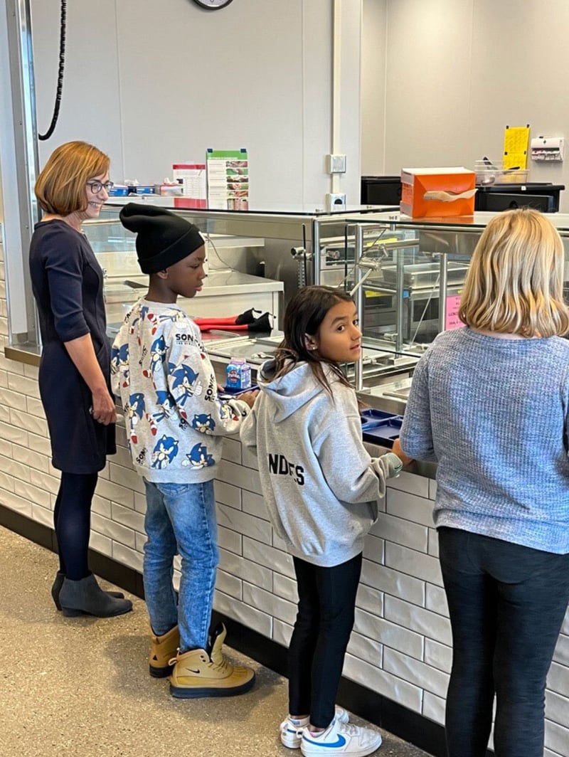 Food and Nutrition Service Administrator Cindy Long waits for a nutritious school lunch with students from Granite Ridge School in Cottage Grove, Wisconsin.