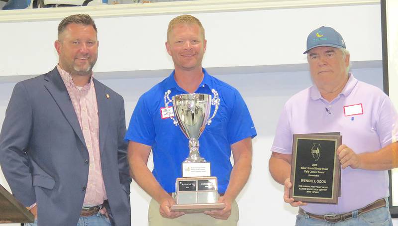 AGRINEWS PHOTO/TOM C. DORAN
Wendell Good (right) was the winner of the Illinois Wheat Association’s winter wheat yield contest this year with an average of 147.73 bushels per acre. Matt Wehmeyer, president of Wehmeyer Seed and AgriMaxx Wheat, holds the traveling trophy presented to the company providing the top yield variety. John Howell (left), IWA president, announced the top yields.