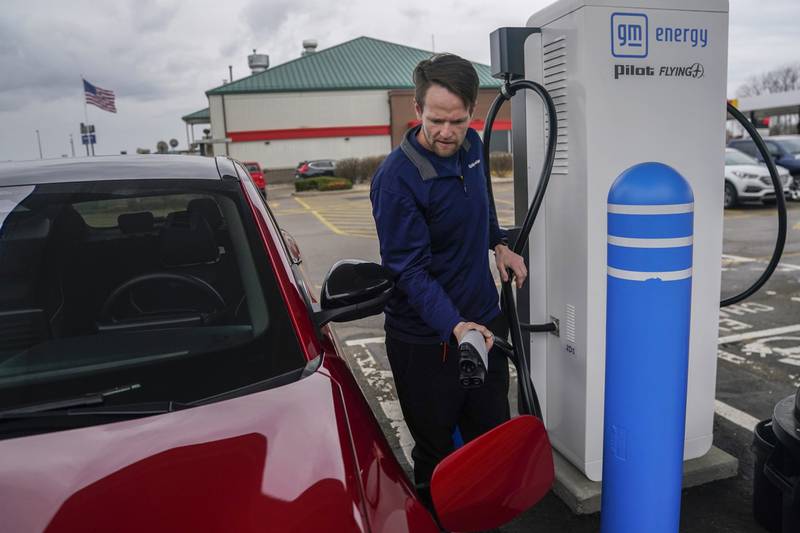 Liam Sawyer, of Indianapolis, charges his 2023 Ford Mustang Mach-E at an electric vehicle charging station in London, Ohio. The charging ports are a key part of President Joe Biden’s effort to encourage drivers to move away from gasoline-powered cars and trucks that contribute to global warming.