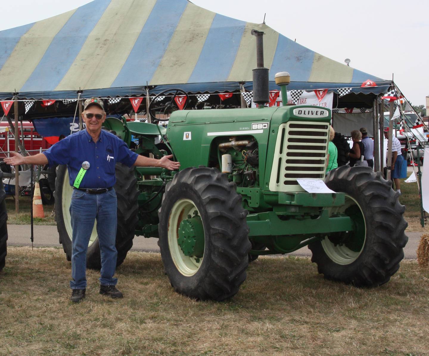 Oliver Schaefer, who fueled Sherry’s passion for Oliver tractors, stands by an 880 front wheel assist tractor that is just one of the unique tractors that he built in his shop and now is in Sherry’s collection.