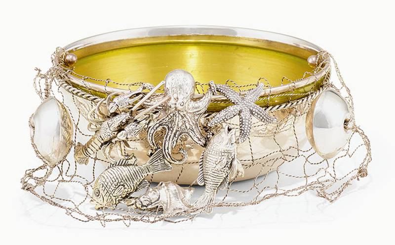 Three-dimensional figures of animals and wildlife are often seen on elaborate silver pieces. This bowl takes a slightly different approach, with figures of sea animals attached to a wire net.