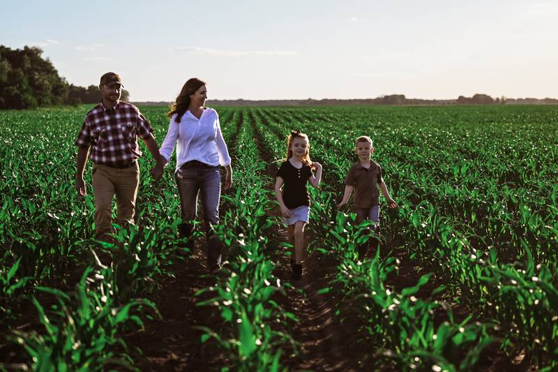 Craig Stevenson (from left) and wife Elizabeth walk through a field with their children Paisley, 8, and Archer, 5.