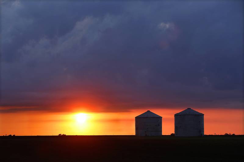 Storm clouds form over central Illinois corn and soybean grain bins in Pleasant Plains, Illinois.