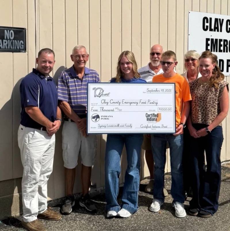 Mike Robinson, executive director of the Clay County Emergency Food Pantry (second from left) accepts a $5,000 ground pork donation from Sydney Lowdermilk (third from left). Other members of the Lowdermilk family were also present.