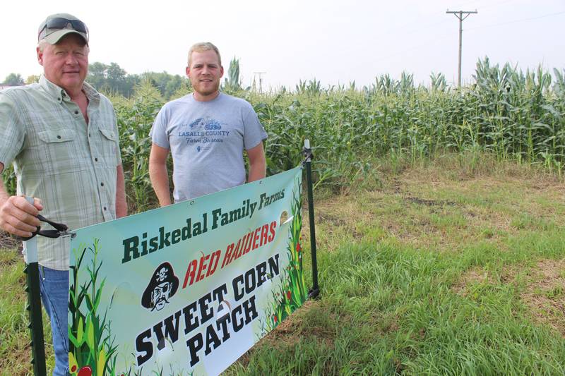 Brad Riskedal (left) and Stephen Riskedal show the sign that is posted near the sweet corn patch by their shop on Route 23 in northern Illinois. The u-pick patch is expected to be open Aug. 15-30.