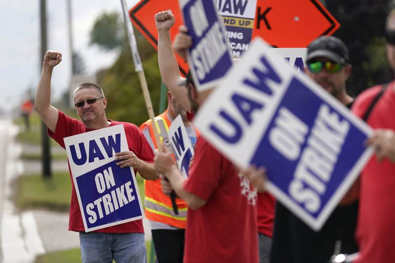 United Auto Workers member Mariusz Mirek holds a picket sign near a General Motors Assembly Plant in Delta Township, Michigan. The UAW union expanded its strikes against Detroit automakers, adding 7,000 workers at a Ford plant in Chicago and a General Motors assembly factory near Lansing, Michigan.