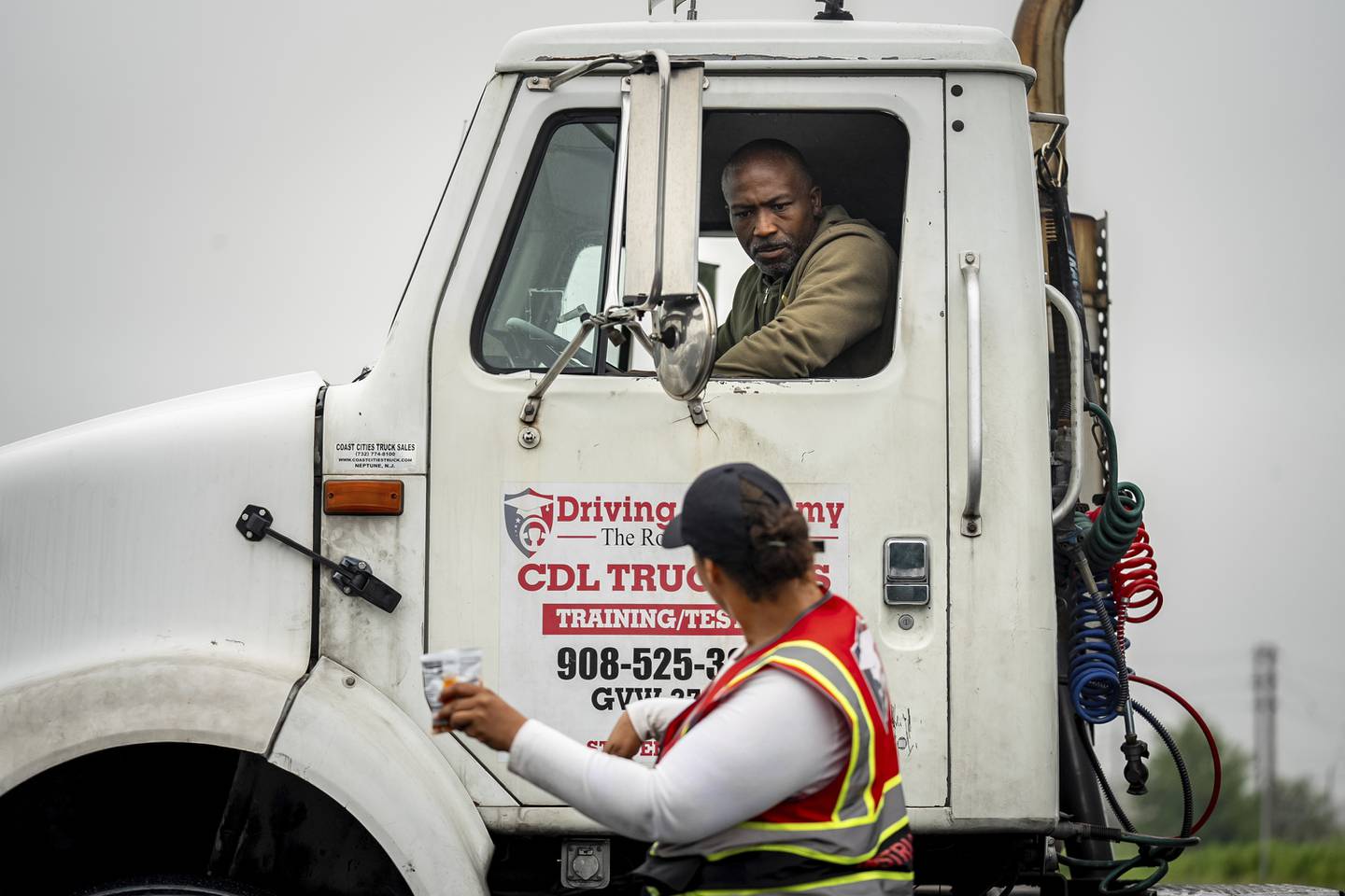 An instructor provides reverse parking advice to a student at the Driving Academy in Linden, New Jersey, where students prepare to obtain a commercial driver’s license with multilingual instructors.