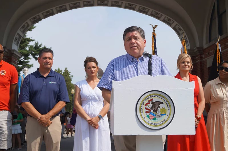 Gov. JB Pritzker speaks to reporters outside the Illinois State Fairgrounds after cutting a ribbon to officially open the fair on Aug. 7.