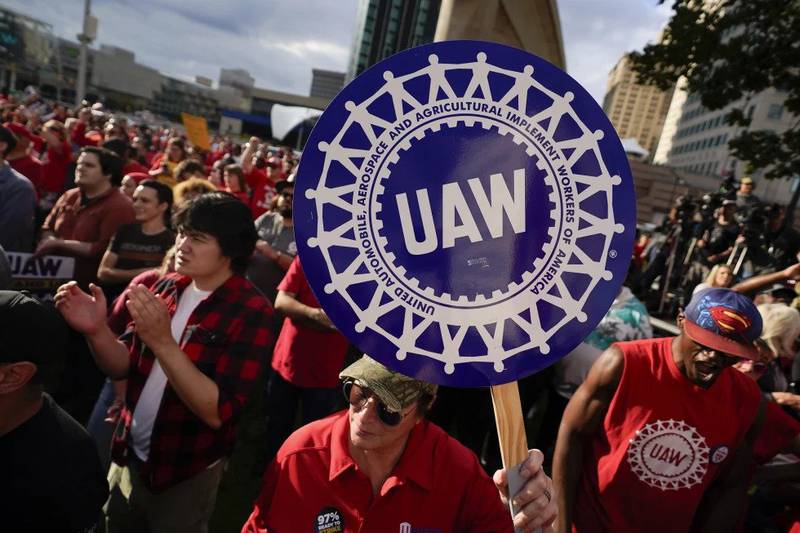 United Auto Workers members join the picket line in Detroit on Sept. 15. General Motors says pretax earnings took a $1.1 billion hit this year from the six-week strike, but the company expects to absorb the costs of a new contract and is even raising its dividend.