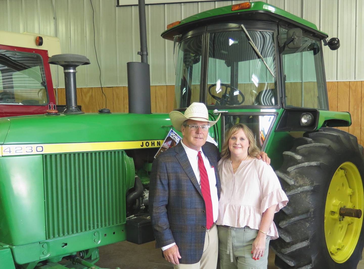 Dan and Kacey Sullivan stand next to the 1976 John Deere 4230 tractor with 2,944 hours they donated with 100% of the “hammer price” going to Farm Rescue. The tractor will be among those auctioned off at the Farm Progress Show on Aug. 27 in Decatur, Illinois.