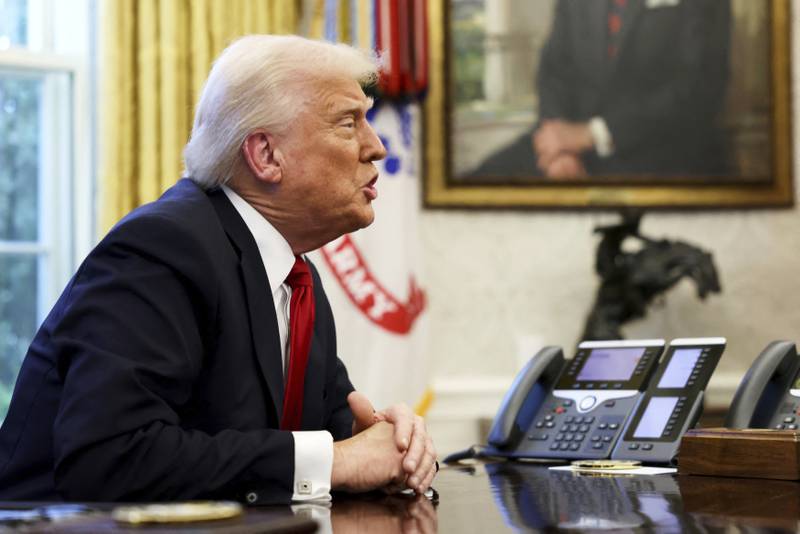 President Donald Trump speaks to reporters in the Oval Office at the White House in Washington.
