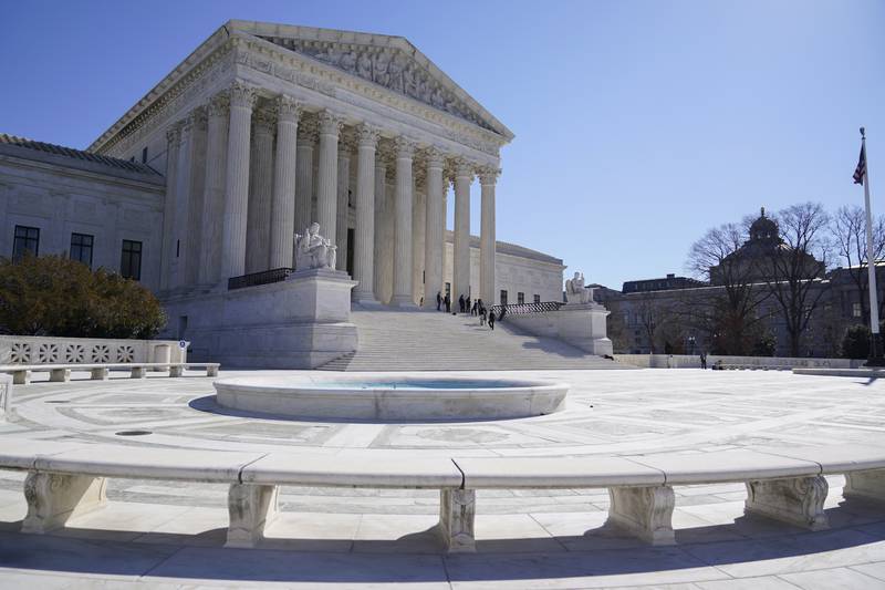 People stand on the steps of the U.S. Supreme Court in Washington. The Supreme Court is taking up challenges by commercial fishermen to a fee requirement that could achieve a long-sought goal of business and conservative interests, limiting a wide range of government regulations.