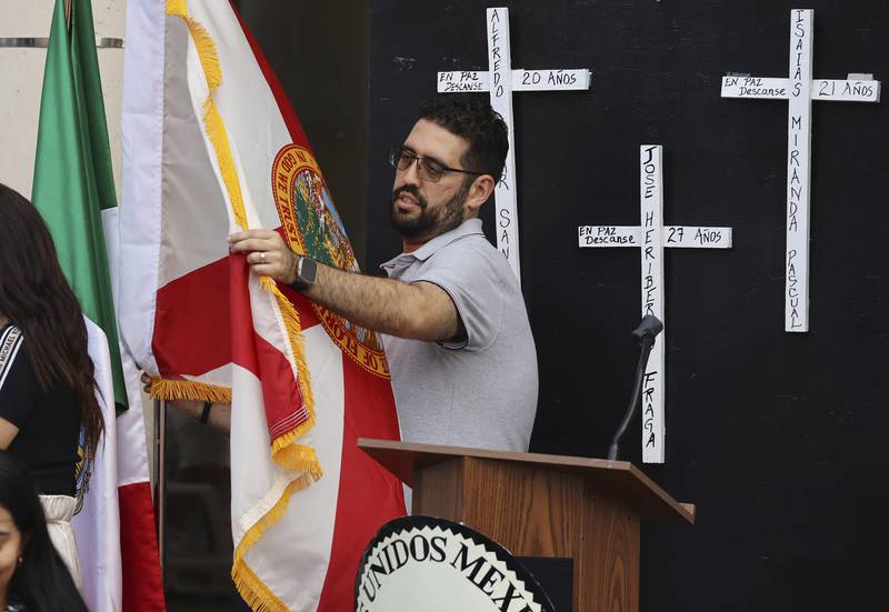 A flag is unfurled in front of the Mexican Consulate in Orlando, Florida, for a vigil honoring the eight Mexican farmworkers who were killed in a bus crash.