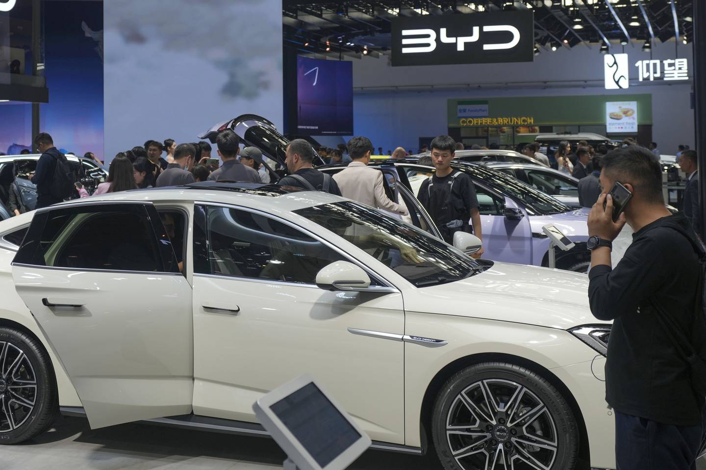 Visitors look at cars at the BYD booth during the China Auto Show in Beijing, China, April 26, 2024.