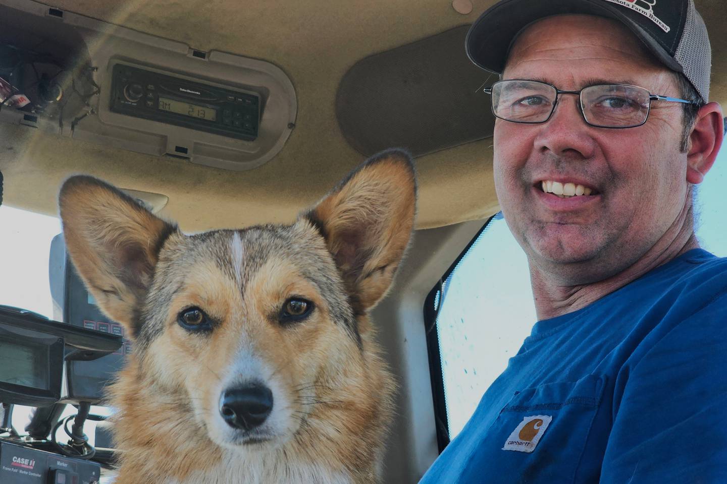 Dan Glessing and his corgi, Georgie, are shown in his tractor as they prepare to take a break from planting soybeans.