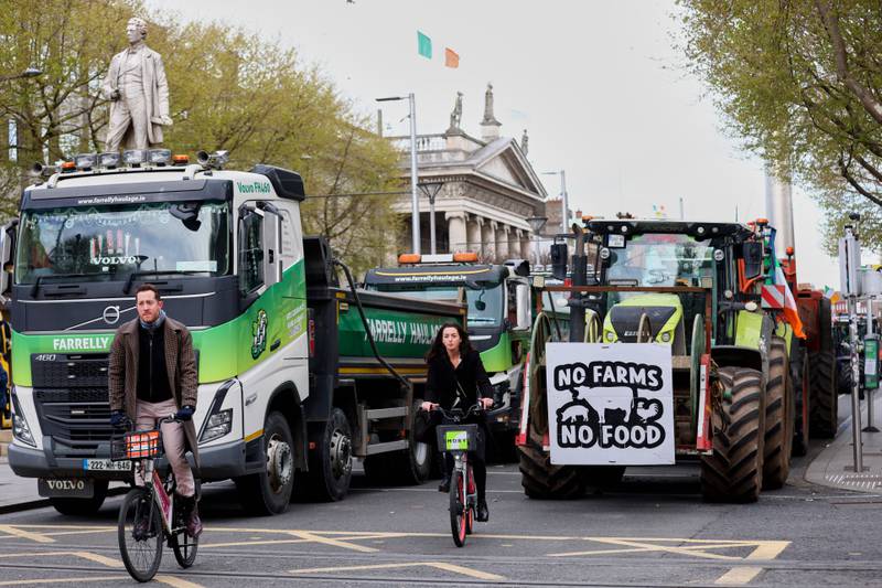 Cyclists ride past tractors blocking O'Connell Street on the fifth day of the National Fuel Protest in Dublin.