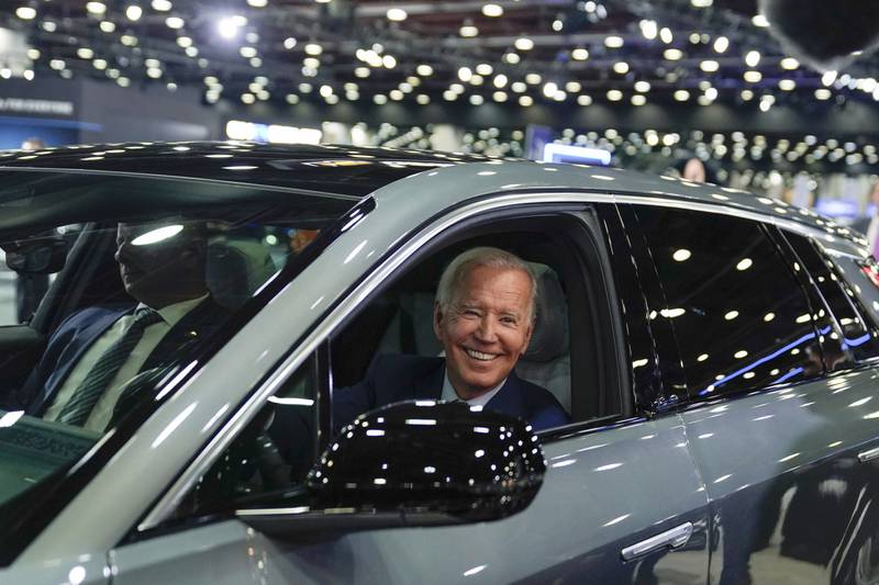 President Joe Biden drives a Cadillac Lyriq through the show room during a tour at the Detroit Auto Show in 2022.