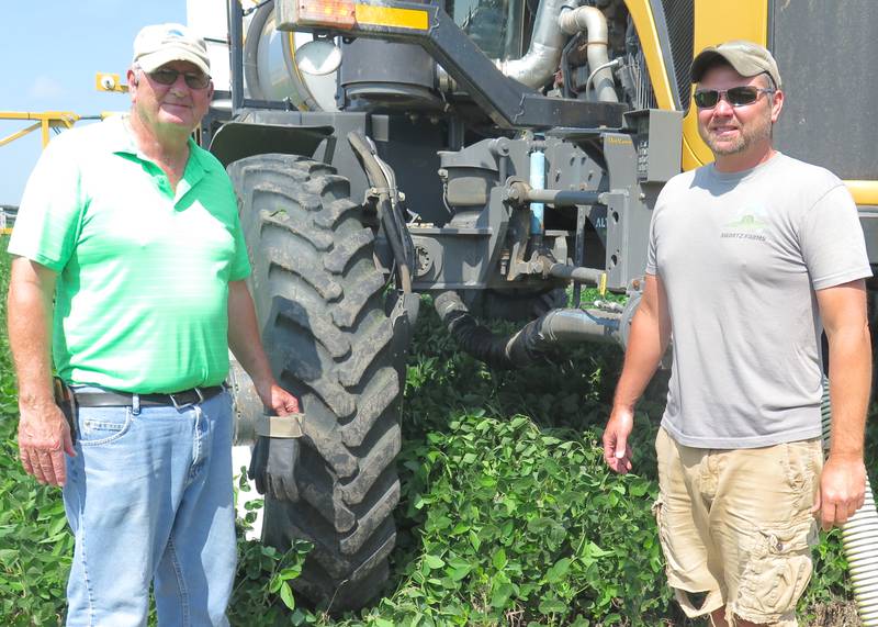 Craig Swartz (right) was applying fungicide, insecticide and foliar nutrition on soybeans, with his dad, Gary Swartz, loading product into the applicator on July 23 in a field east of Pontiac, Illinois.