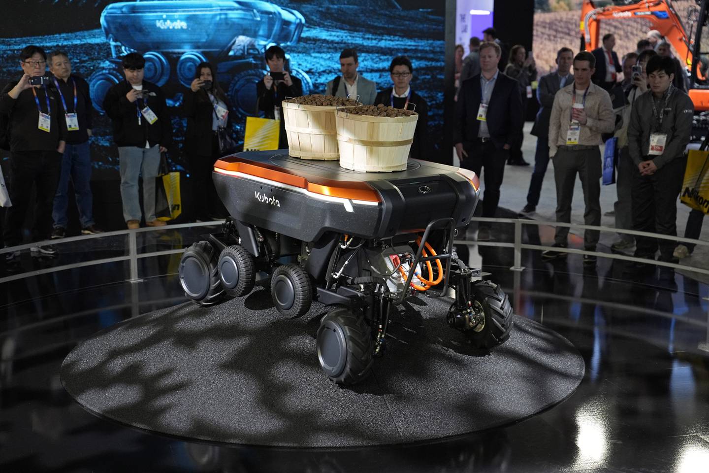 People view a demonstration of the KATR robot designed to work in agriculture and construction at the Kubota booth during the CES tech show in Las Vegas.