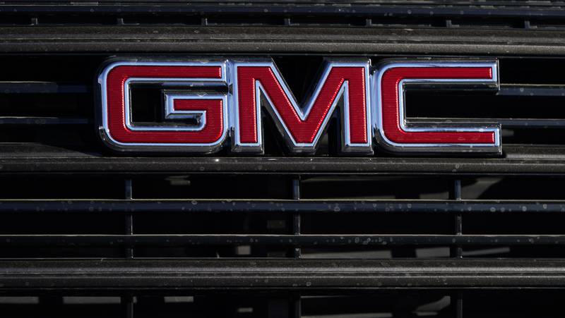 A GMC company logo is displayed at a GMC Truck dealership in Castle Rock, Colorado.