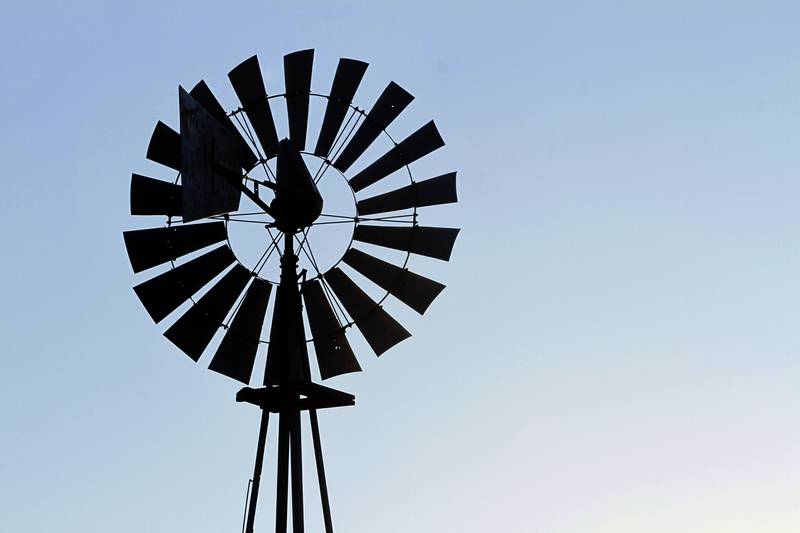 A windmill is seen on a farm as the sun rises in Pleasant Plains in central Illinois.