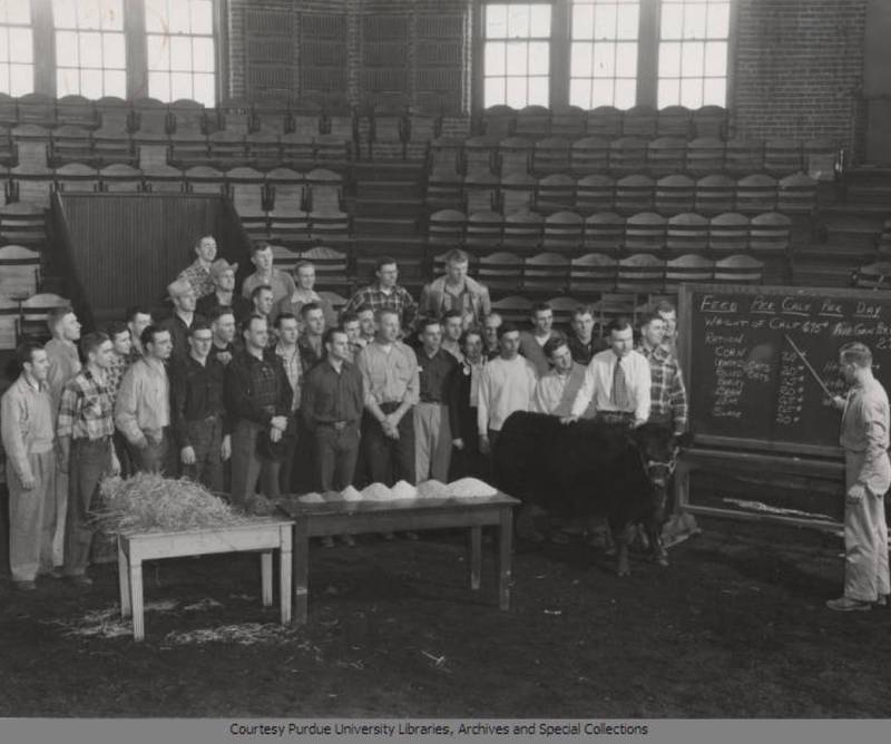 A historic photo shows students and a professor in the animal science department at Purdue University.