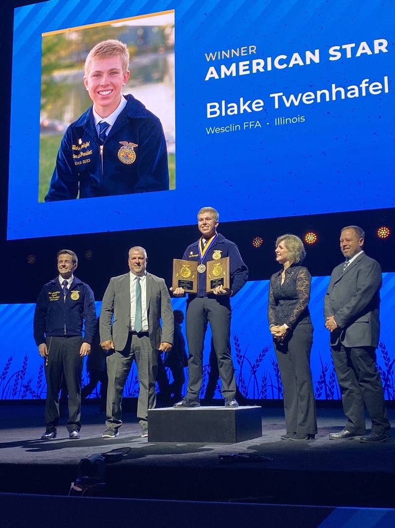 The American Star in Agribusiness, Blake Twenhafel (center) receives his award on the National FFA Convention & Expo stage. Joining him for the presentation included Jack Lingenfelter (from left), National FFA southern region vice president; Matt Fisher, his FFA adviser; and his parents, Angie and Michael Twenhafel.