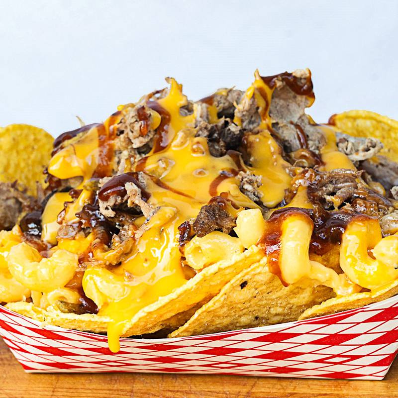 BBQ Machos by Nitro Hog BBQ. BBQ Machos are here- tortilla chips topped with creamy mac and cheese, smoky pulled Pork and cheese sauce. Swing by Nitro Hog BBQ at Lot 421 in front of the Coliseum. BBQ sauce is available if you want to sauce it up.